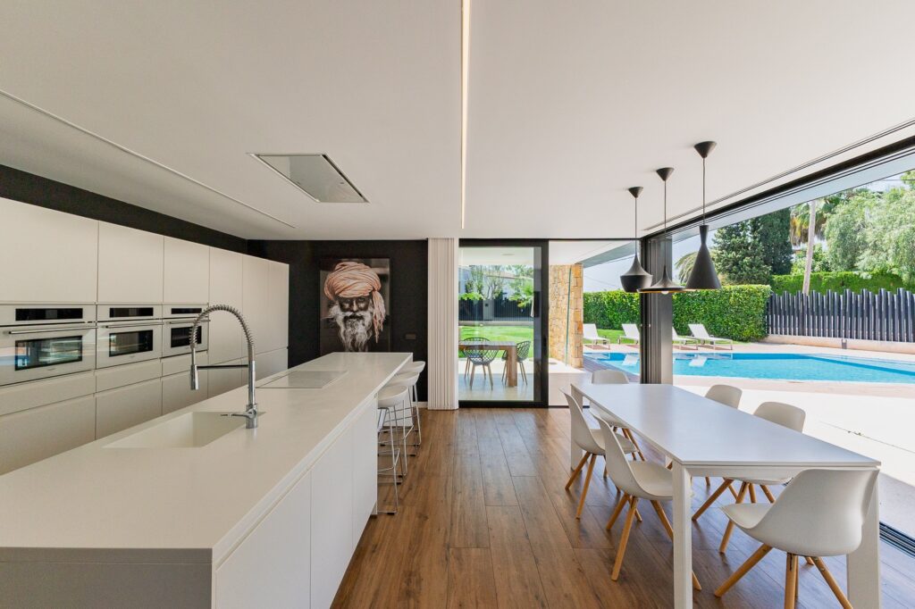 Cocina abierta a terraza y piscina en un chalet, fotografía inmobiliaria profesional