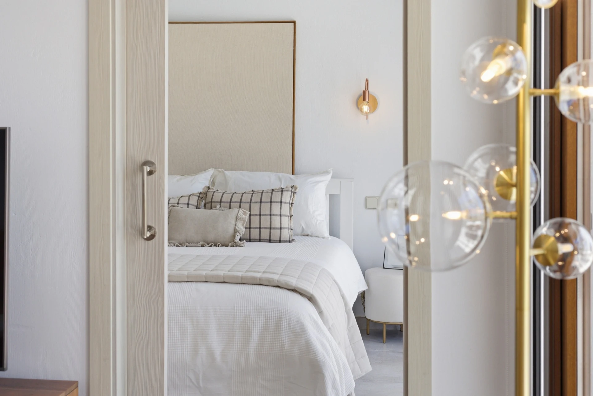 Detalle de una lámpara de cristal con el dormitorio al fondo