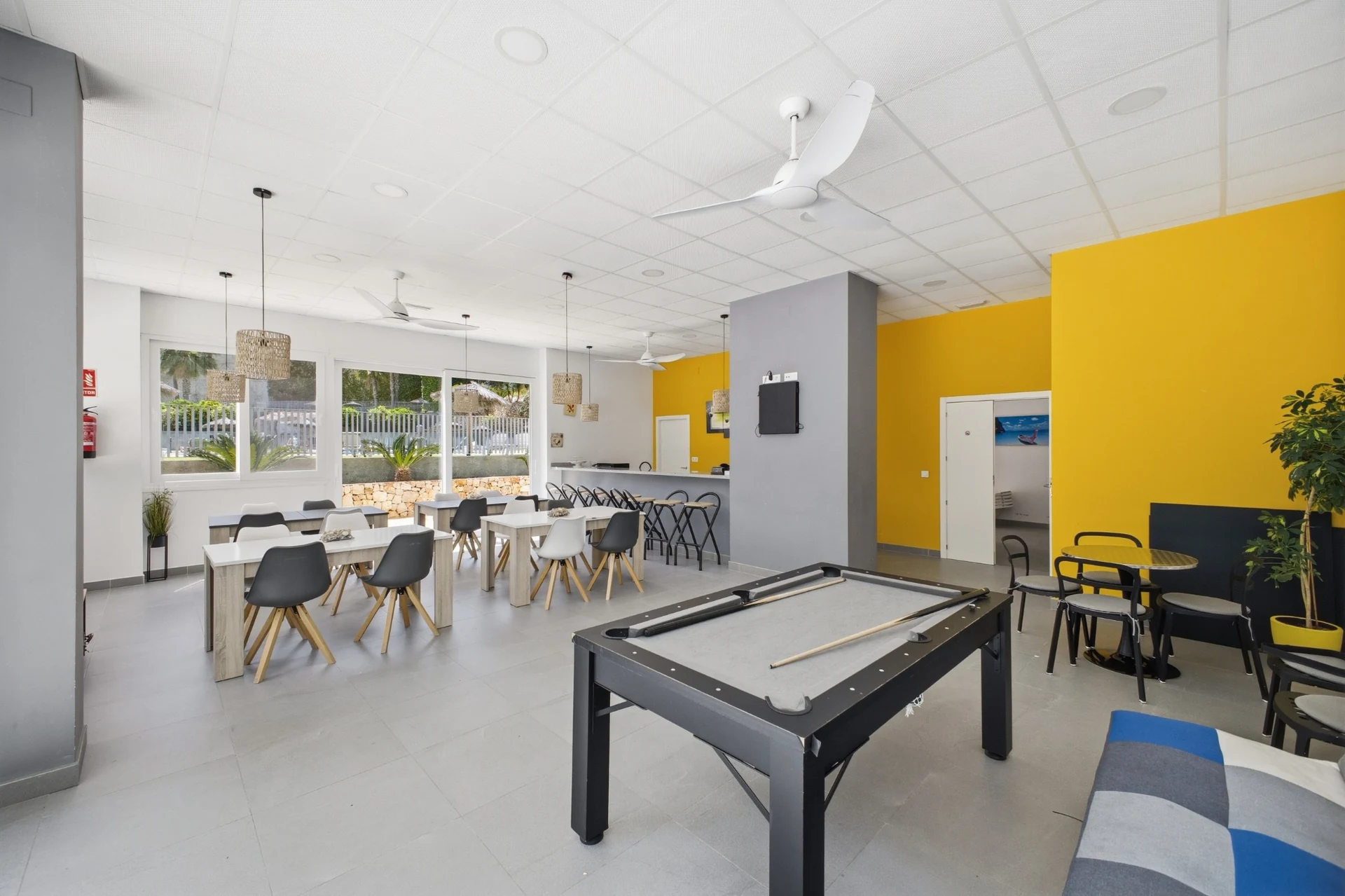 Sala comunitaria con mesas, billar y zona de estar