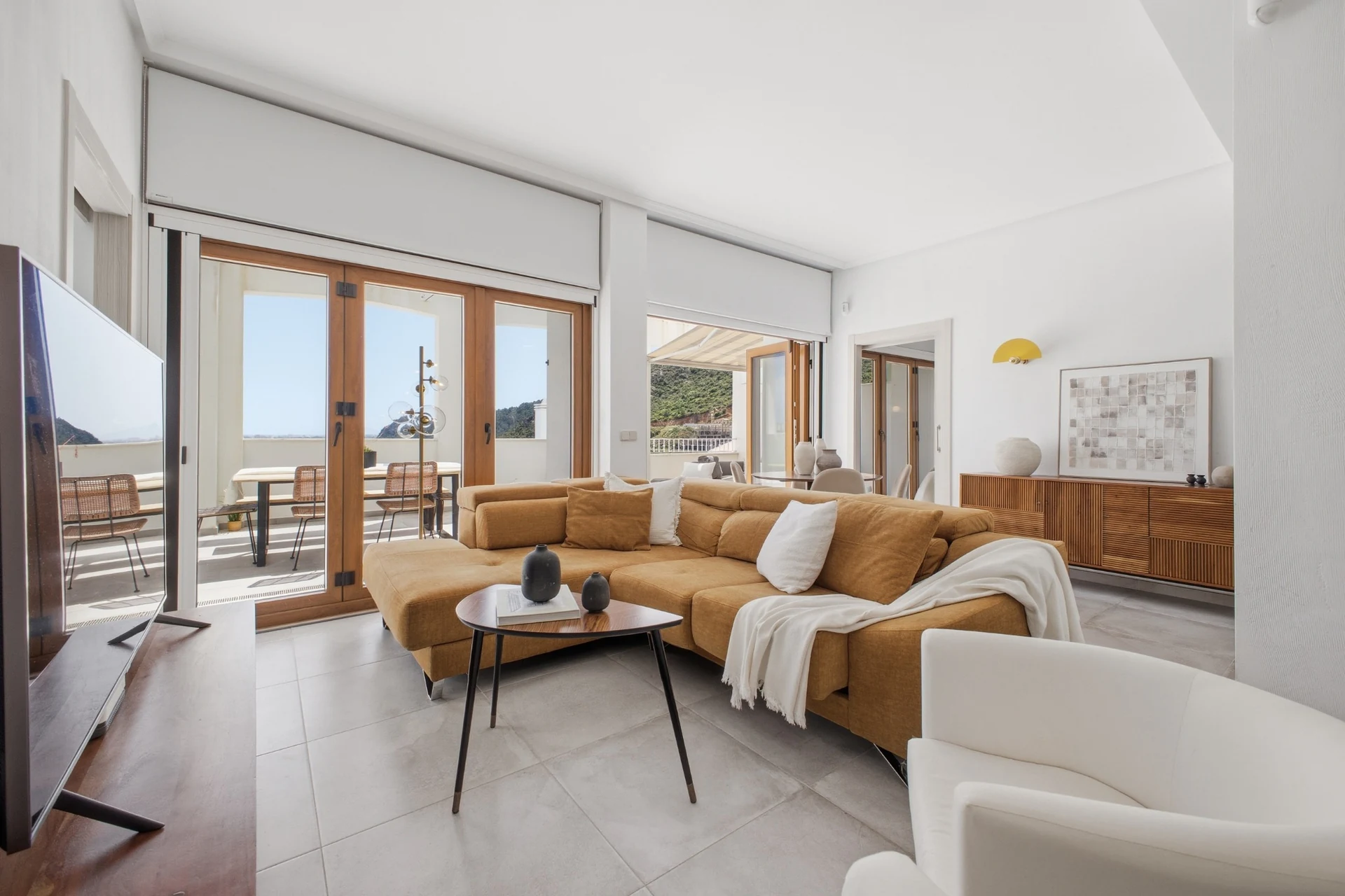 Salón con sofá y puertas abiertas a la terraza